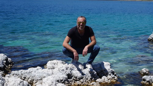 Portrait of man on rock in sea