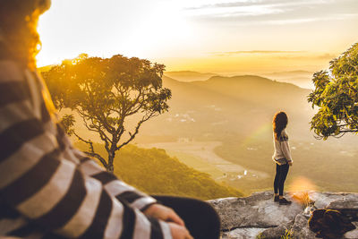 Man looking at mountains against sky during sunset