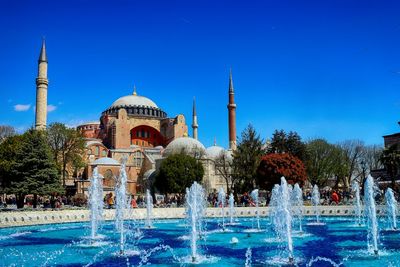 Water fountain and hagia sophia against clear blue sky