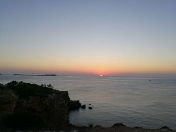 Scenic view of sea against clear sky at sunset