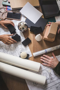 Cropped hands of female architects working over table