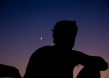 Silhouette man standing against sky at night