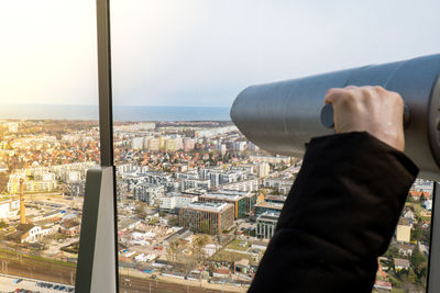Using tourist binoculars look the sea horizon old city from the roof top in gdansk. oliva star