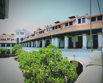 View of bridge by buildings against sky