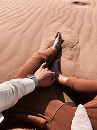 High angle view of people hands on sand