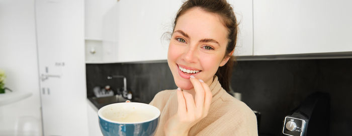 Portrait of young woman drinking glass