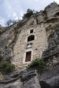 Low angle view of old building by mountain against sky