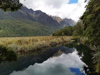 Scenic view of lake and mountains against sky