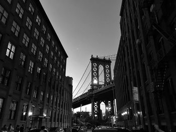 Low angle view of bridge in city against sky