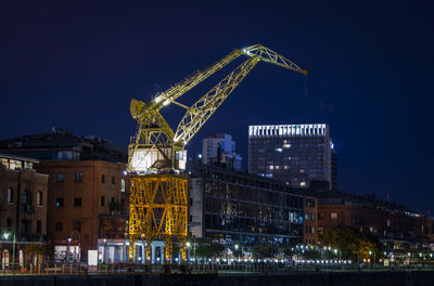 Illuminated cityscape against sky at night