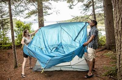 Man standing in tent against trees in forest