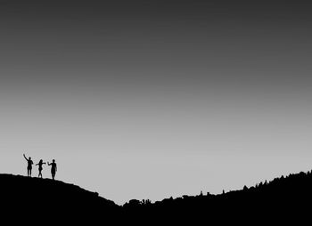 Silhouette people standing on land against sky