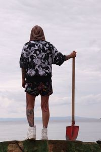 Rear view of woman looking at sea against sky