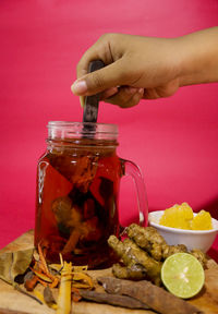 Close-up of hand holding glass jar on table