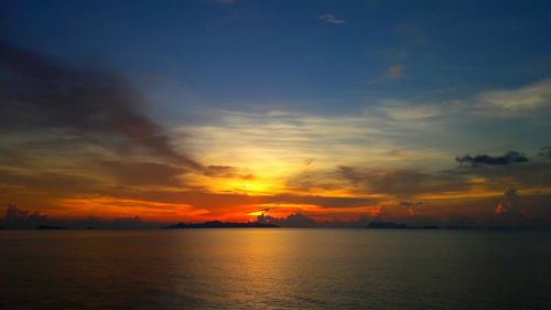 Scenic view of sea against dramatic sky during sunset