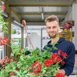 Portrait of smiling young man holding flower bouquet