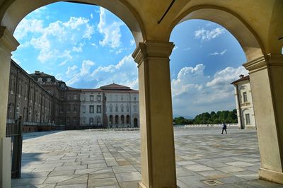 Panoramic view of buildings against cloudy sky