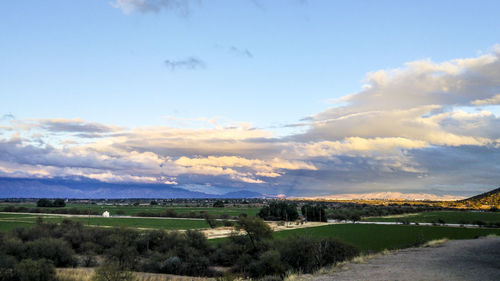 Scenic view of agricultural field against sky at sunset