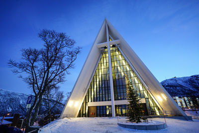 Low angle view of illuminated building against clear blue sky