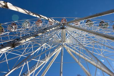 Low angle view of ferris wheel against clear blue sky