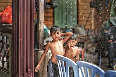 Kids playing out in the rain. children play outdoors in heavy rain, caught in first spring rainy day