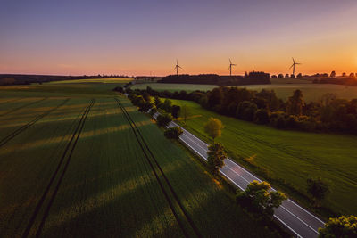 Scenic view of agricultural field against sky during sunset