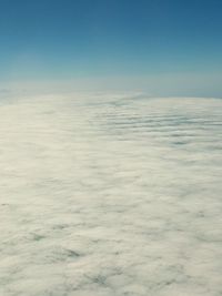 Scenic view of cloudscape over sea against blue sky