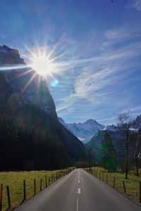 Empty road along landscape and mountains against sky