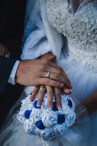 Midsection of groom holding bride hand