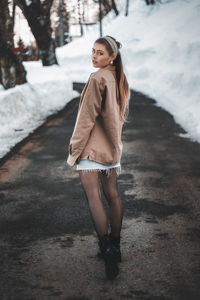 Portrait of young woman standing in snow