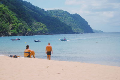 People enjoying on beach against sky