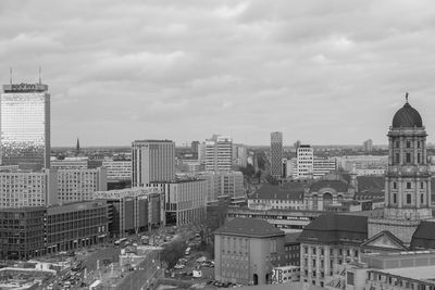 High angle view of city buildings against cloudy sky