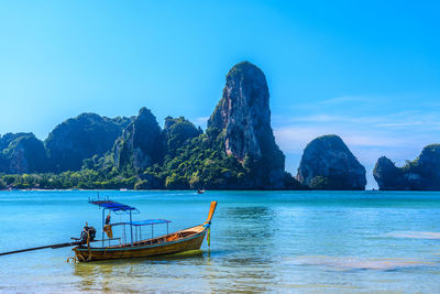 Scenic view of sea and mountains against blue sky