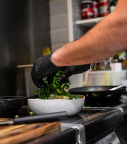 Midsection of person preparing food in kitchen