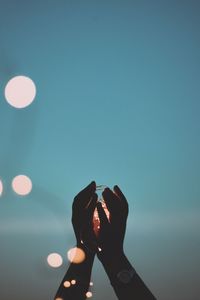 Midsection of person photographing against clear blue sky