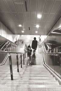 Rear view of people walking on subway station