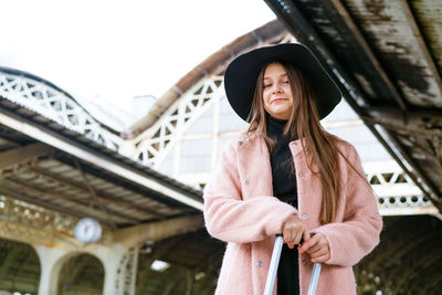 Woman traveler tourist walks with luggage at the train station. the concept of