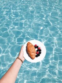 High angle view of hand holding ice cream in swimming pool