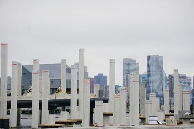 Smoke stack and buildings in city against sky