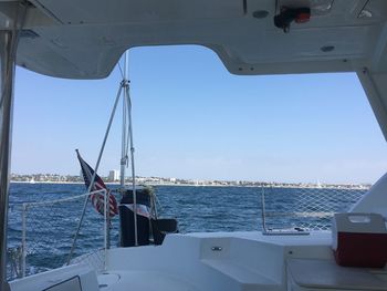 Boat sailing on sea against clear sky