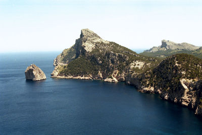 Scenic view of sea and rocks against clear sky