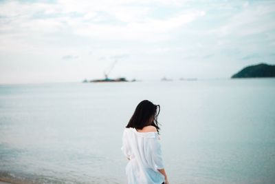 Rear view of woman looking at sea against sky