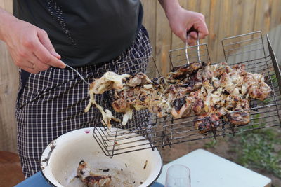 Midsection of man preparing food on barbecue grill