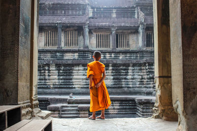 Rear view of a man standing outside temple