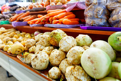 Celery, turnip, carrots, onions, roots and other various vegetables are sold on market shelves.