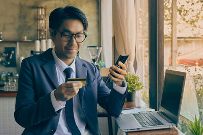 Young man using mobile phone at home