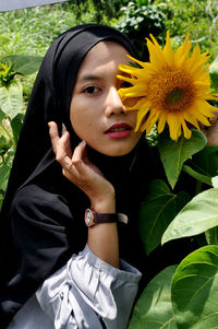 Portrait of woman with yellow flower