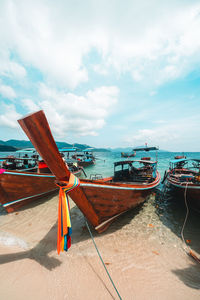 Boat moored on beach against sky