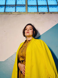 Portrait of woman standing against  wall