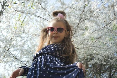 Portrait of a smiling young woman against trees